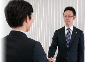 握手を交わす本田健弁護士